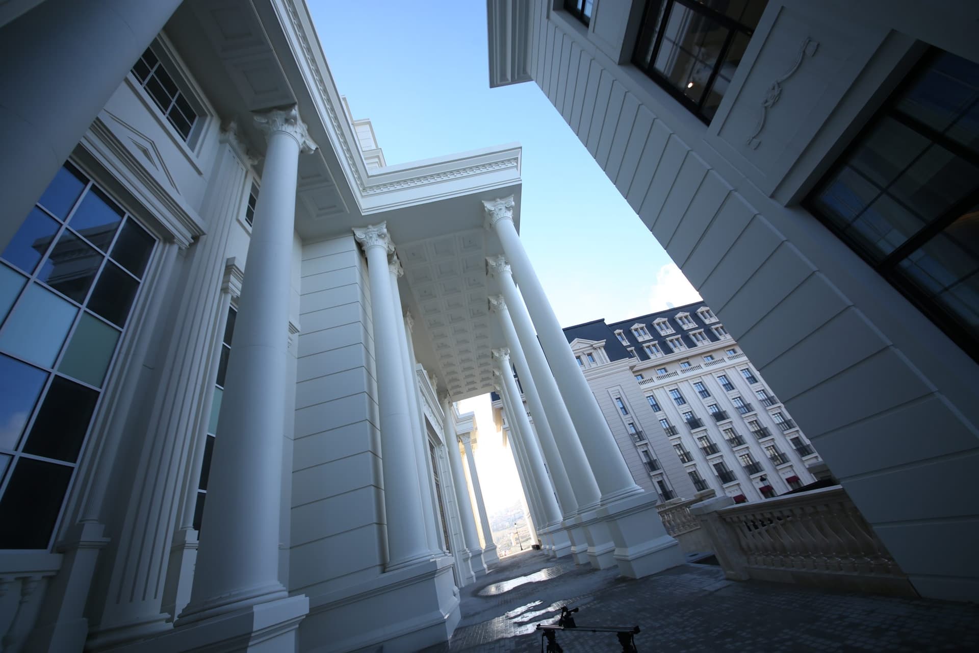 A colonnade on the campus, with university buildings beyond.