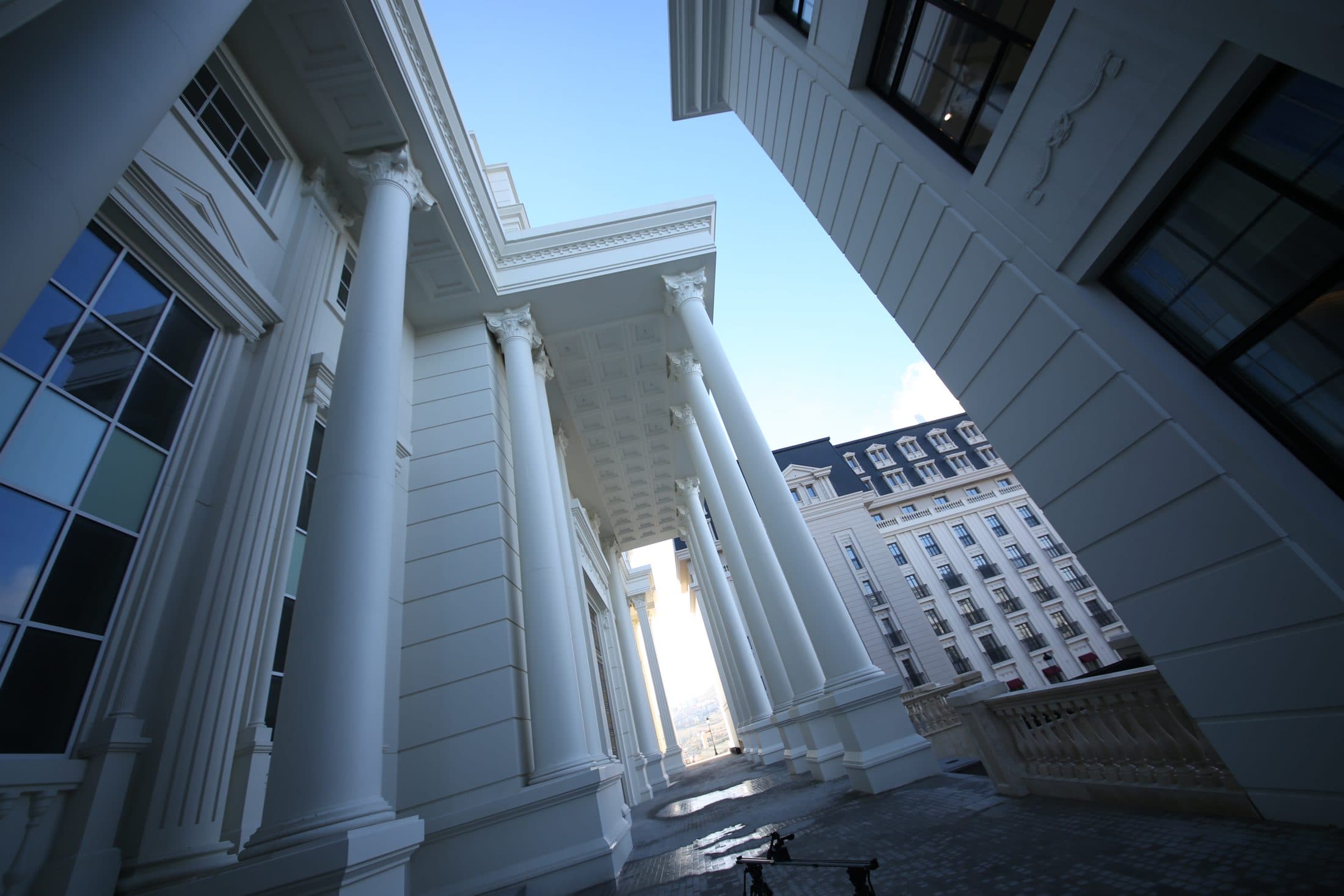 A colonnade on the campus, with university buildings beyond.