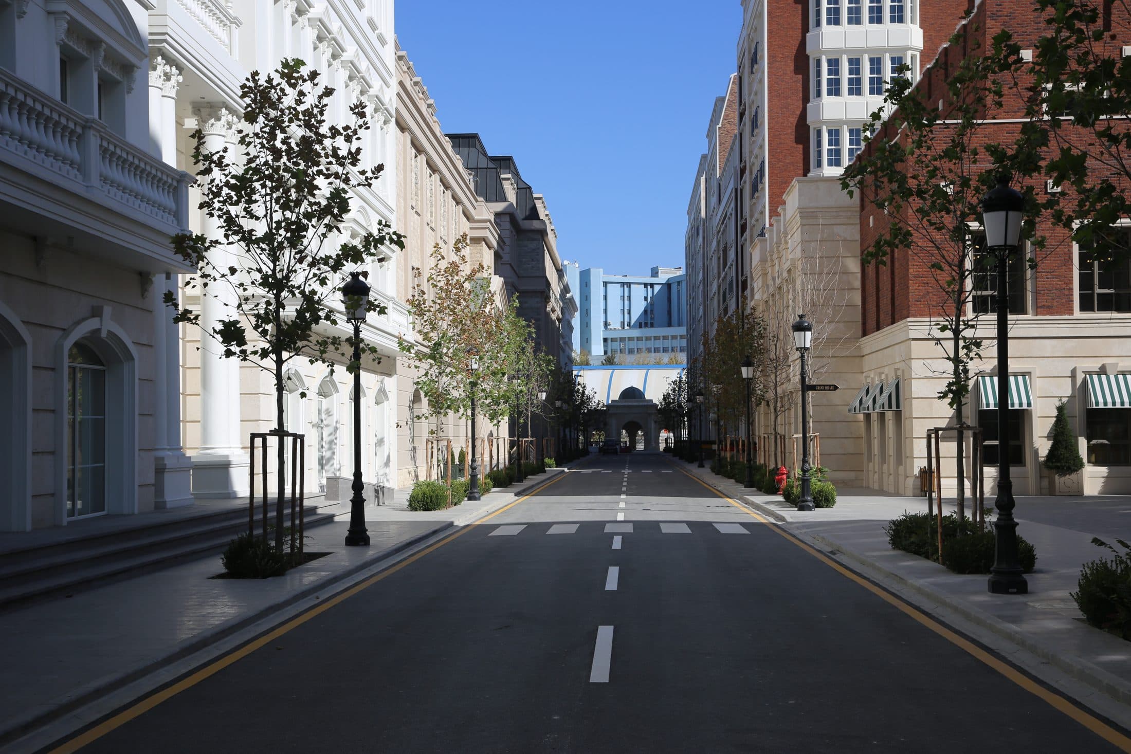 A campus street between university buildings, with no people in view.
