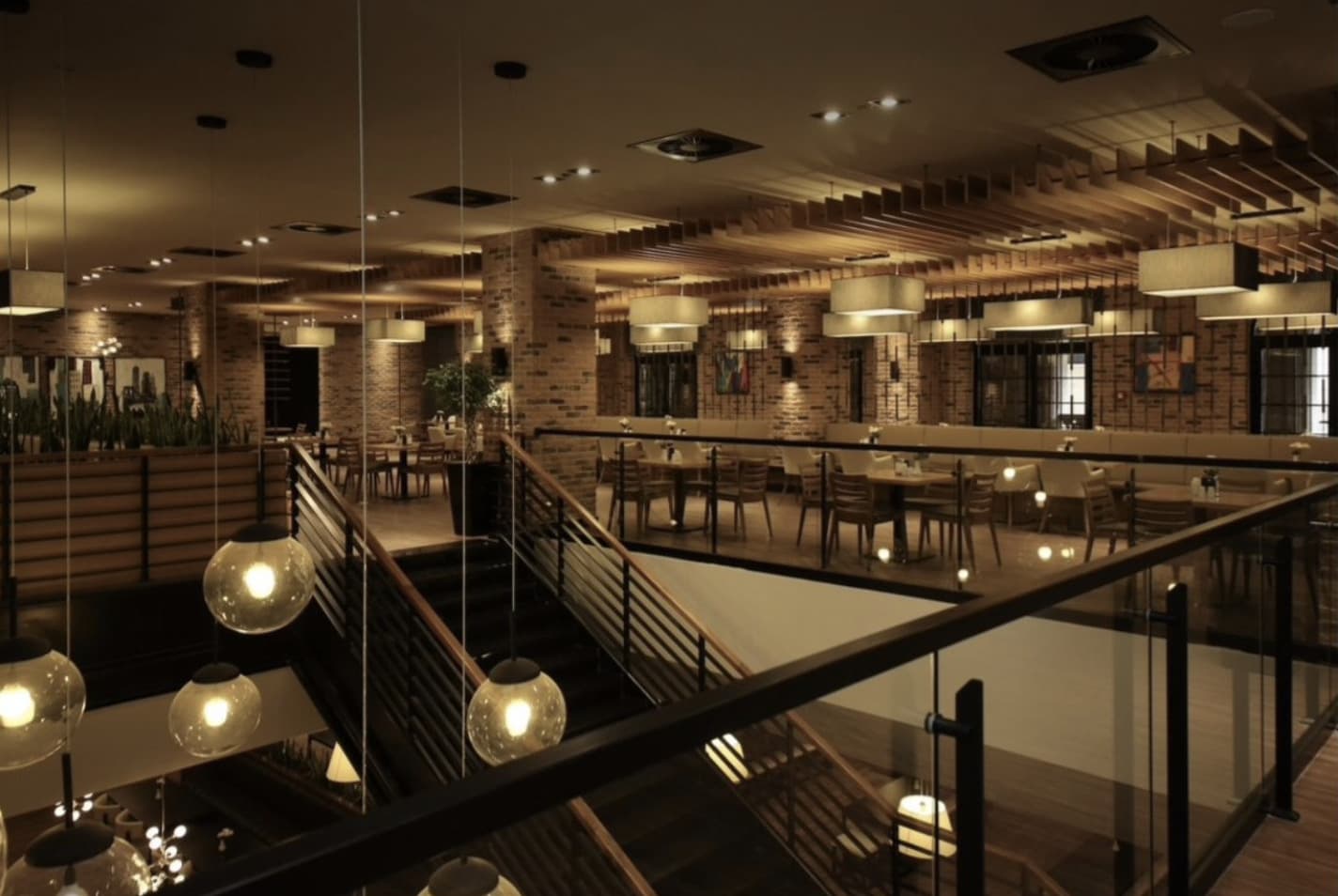 An interior dining space seen from globe-lit stairs.