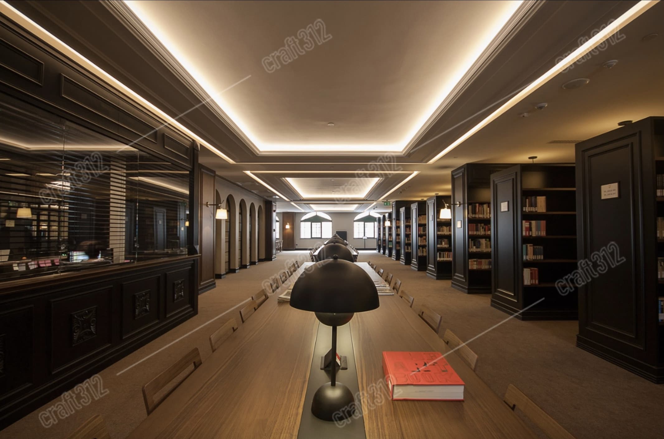 A library interior with a long table, bookshelves and a dome lamp.