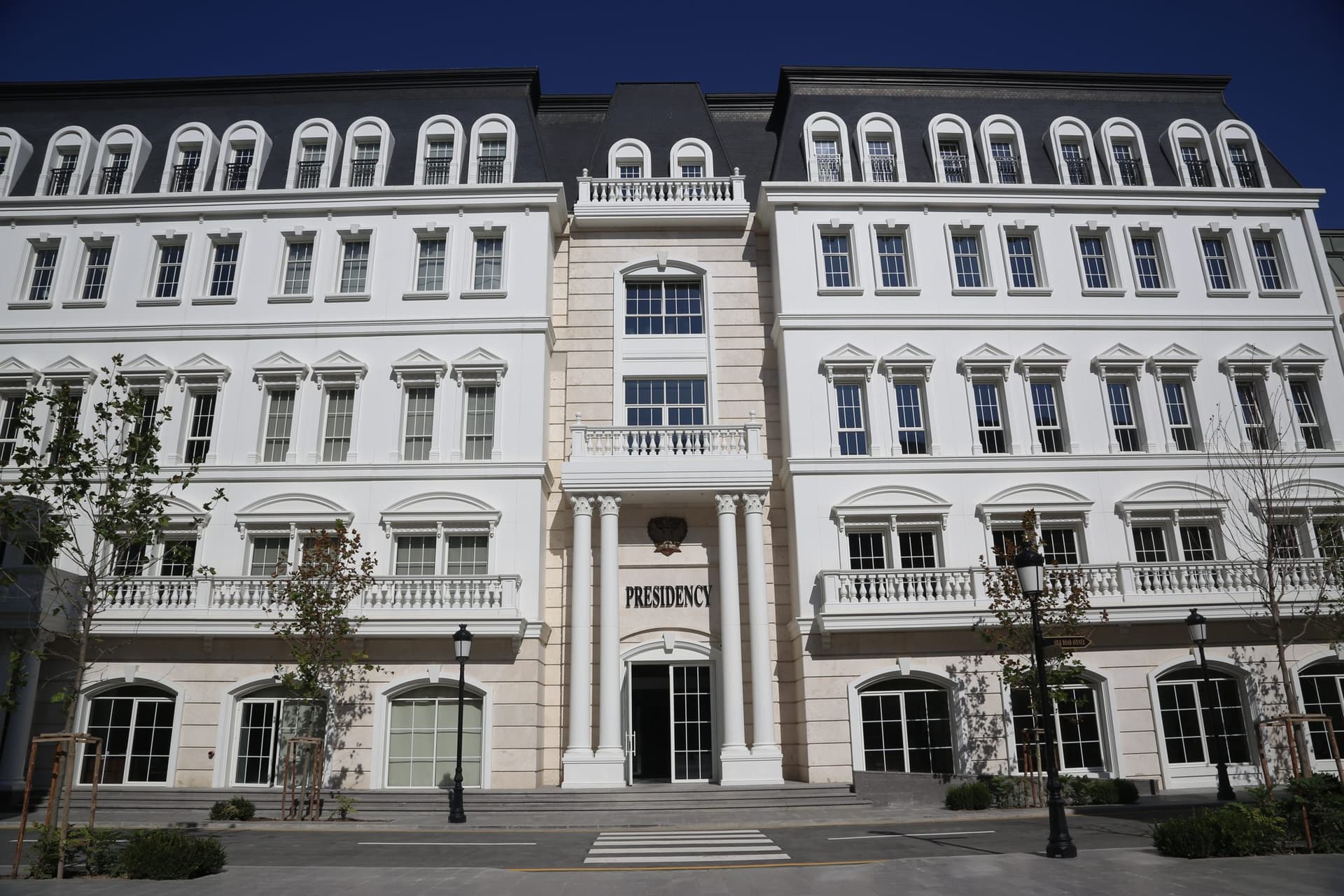 A white campus building whose entrance is inscribed Presidency.