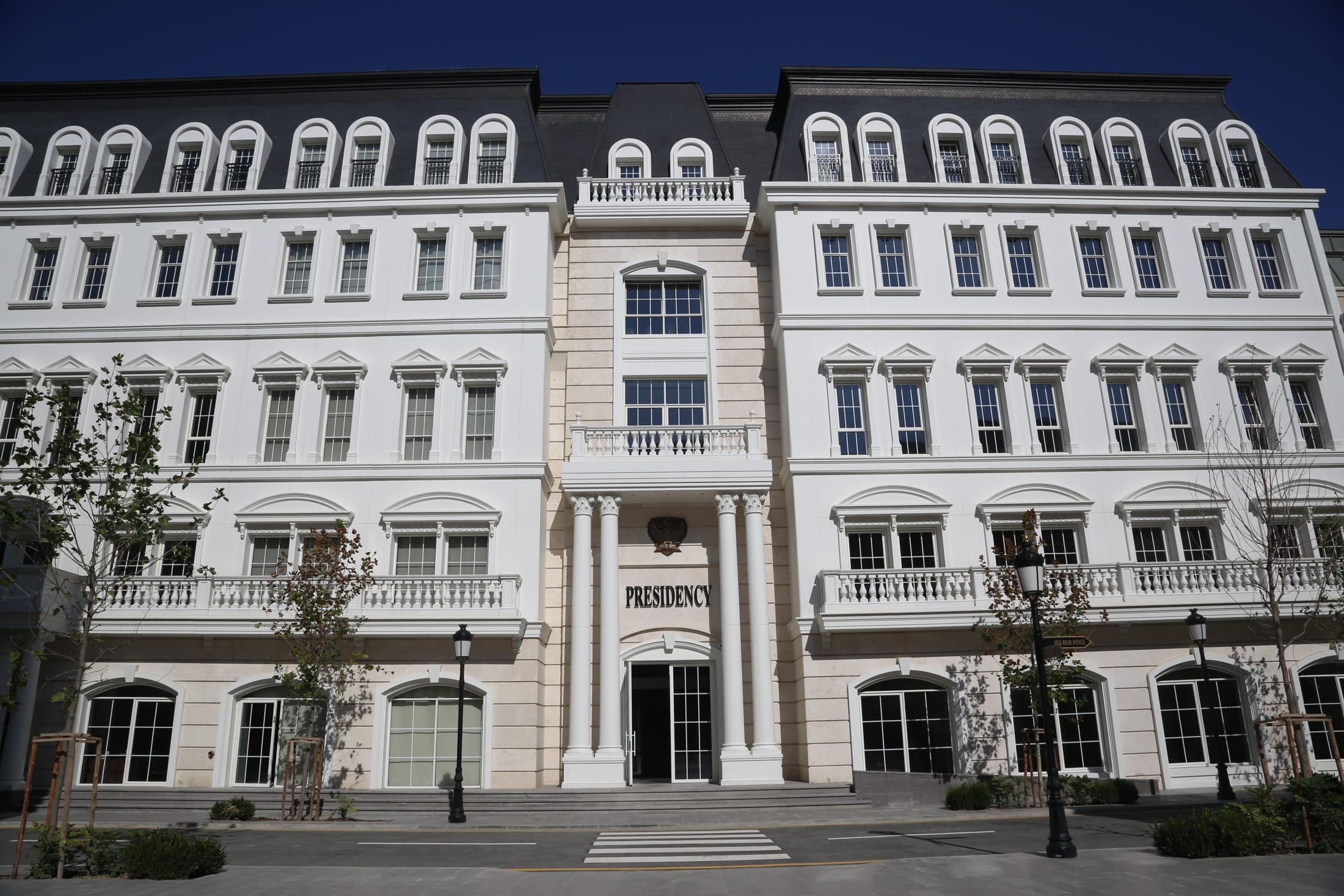 A white campus building whose entrance is inscribed Presidency.